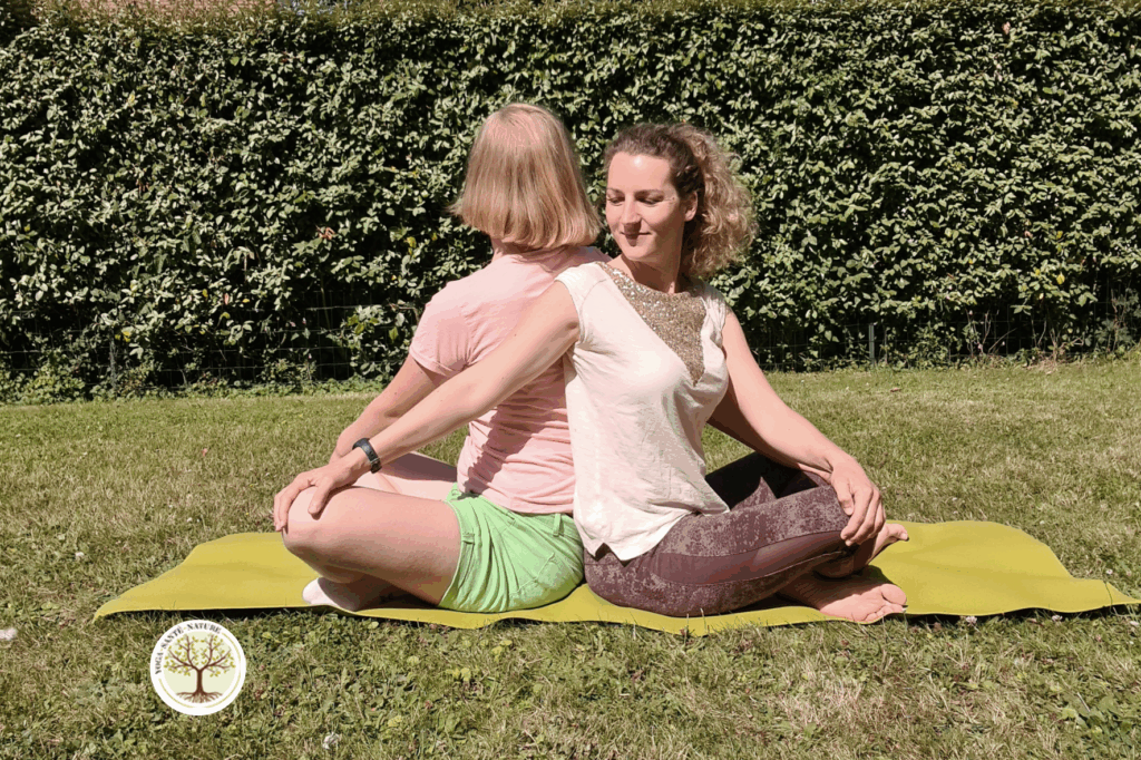 Photo d'une posture de torsion en yoga travaillant la sensorialité par le toucher et le lien parent-enfant dans le cas d'une enfant autiste ou TDAH