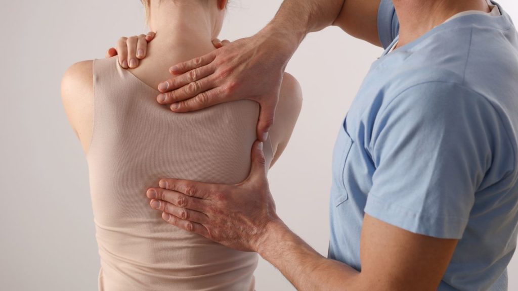 Kinésithérapeute accompagnant une personne dans un travail corporel autour du dos et de la respiration.
